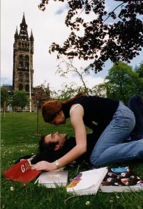 Students lay on the grass on campus kissing Students lay on the grass on campus kissing