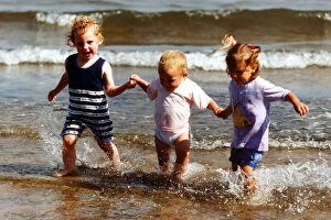 Images Dated 9th August 1998: Summer Weather Scenes - Sunbathing Sisters Ellie Woodhead, 3, (stripes), Katie, 2