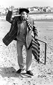 Television comedian Norman Colliercarrying a deckchair on the beach April 1991 Television comedian Norman Colliercarrying a deckchair on the beach April 1991