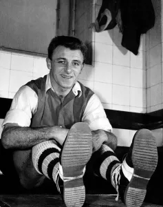 Tommy Docherty Football player for Arsenal who shows off his boots that helped him win Tommy Docherty Football player for Arsenal who shows off his boots that helped him win