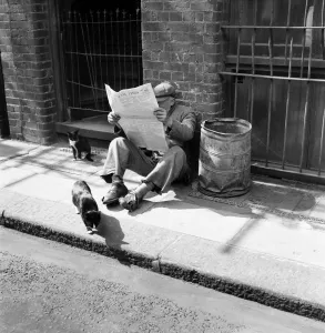 A tramp sitting down on the pavement reading the Financial Times A tramp sitting down on the pavement reading the Financial Times