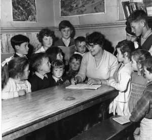 Tryweryn Valley - Mrs Martha Roberts marks the books of her young pupils in the one room Tryweryn Valley - Mrs Martha Roberts marks the books of her young pupils in the one room