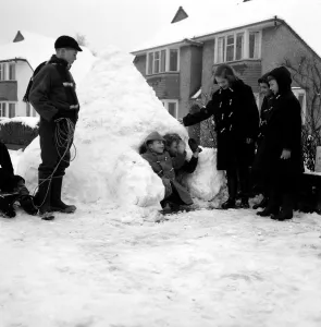 Weather - Snow - Cold Children building a snow house / igloo in the street - waving Weather - Snow - Cold Children building a snow house / igloo in the street - waving