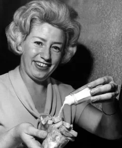 Woman adding salt to a bag of chips - October 1961 Woman adding salt to a bag of chips - October 1961