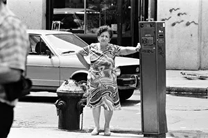 Woman leans against Street Fire Alarm Box, used to report an emergency, New York, USA Woman leans against Street Fire Alarm Box, used to report an emergency, New York, USA