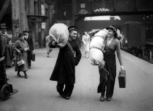 Woman Railway Porter on the station platform carrying luggage for a sailor Circa Woman Railway Porter on the station platform carrying luggage for a sailor Circa