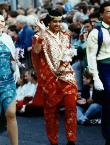 A woman wearing traditional Indian clothing waves to the camera at the 1991 Edinburgh A woman wearing traditional Indian clothing waves to the camera at the 1991 Edinburgh