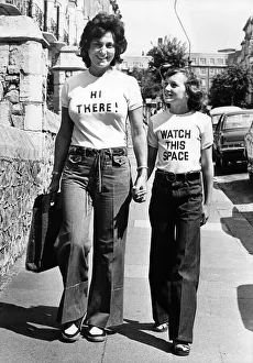Women walking down the street wearing t shirts with amusing slogans August 1976 Women walking down the street wearing t shirts with amusing slogans August 1976