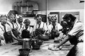 Women wearing gas masks while watching a cookery. June 1941 Women wearing gas masks while watching a cookery. June 1941