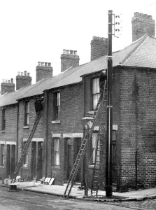 Workmen busy at the poles erected in Shield Street, Gateshead where they are putting Workmen busy at the poles erected in Shield Street, Gateshead where they are putting