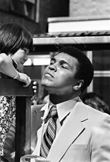 Images Dated 11th August 1977: World Heavy-weight boxing champion Muhammad Ali with a little girl from Great Ormond