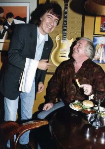 Bill Wyman serves Jimmy Jones comedian at Sticky Fingers restaurant . May 1989 Bill Wyman serves Jimmy Jones comedian at Sticky Fingers restaurant . May 1989