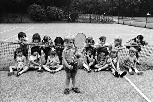 Three year old Daniel Jarmin holds a tennis racket as he poses with other friends in his Three year old Daniel Jarmin holds a tennis racket as he poses with other friends in his