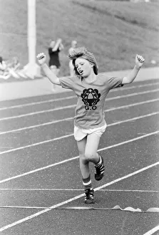 A young boy raises his arms in celebration as he crosses the finish line to win the race A young boy raises his arms in celebration as he crosses the finish line to win the race
