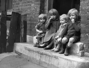 Young children sitting on the doorstep of one of their homes Doris Street, London Young children sitting on the doorstep of one of their homes Doris Street, London