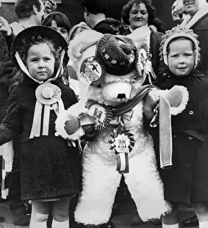 Young female fans of Skelmersdale Football club holding a giant mascot teddy bear as they Young female fans of Skelmersdale Football club holding a giant mascot teddy bear as they