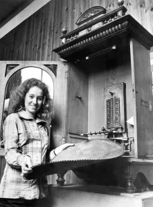 A young girl changes the disc on a vintage juke box or polyphone in September 1972 A young girl changes the disc on a vintage juke box or polyphone in September 1972