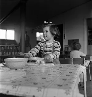 Young girl rolling out dough in cookery class at Cookham Nursery School Young girl rolling out dough in cookery class at Cookham Nursery School