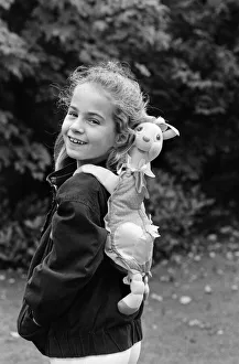 A young girl wearing a soft toy rucksack. 21st October 1986 A young girl wearing a soft toy rucksack. 21st October 1986