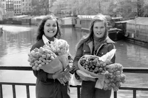 Two young girls of Amsterdam holding bunches of tulips during the season May 1975 Two young girls of Amsterdam holding bunches of tulips during the season May 1975