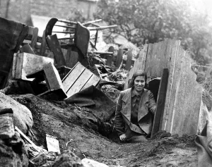 A young lady emerges from an Anderson Shelter after an air raid A young lady emerges from an Anderson Shelter after an air raid