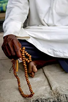 African Muslim Holding Prayer Beads Print