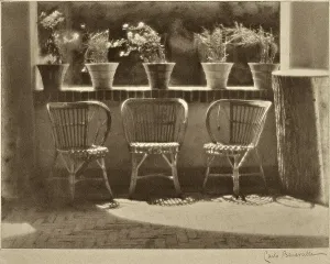 Windowsill. Three wicker armchairs lined up on a terrace, some flowering plants are on the sill