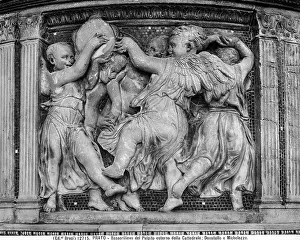 A group of putti playing instruments and dancing. Sculpture by Donatello in one of the panels of the pulpit of Prato's Cathedral