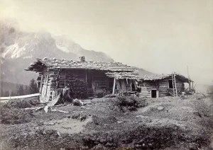 Mountain landscape. In the background, rocky mountains, in the foreground, two chalets