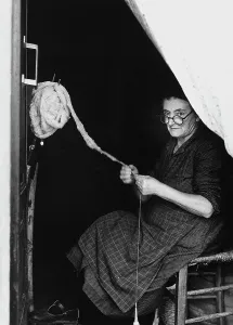 Woman stringing wool