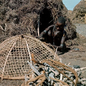 Lake Rudolf Collection: Woman of Turkana ethnicity fixing a fishing net, Island of Lake Turkana