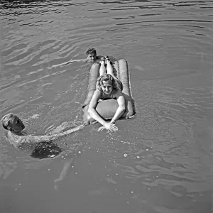 Freizeit Print: Woman on Air Mattress Surrounded by Swimmers
