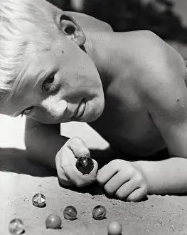 1997 Prints: Close-up Print of a Boy Playing Marbles