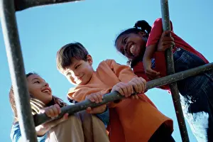 Childhood Friendship Prints: Low angle view of three children playing on a monkey bars
