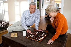 Prints of Mature couple playing backgammon June Prints: Mature Couple Playing Backgammon Print