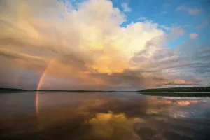 Tranquil Lake Scenery Prints: A rainbow and a dramatic cloud formation over a lake