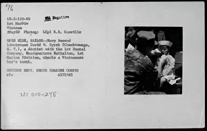 February Prints: Navy Second Lieutenant David W. Syrek examines a Vietnamese boy's teeth in this print