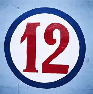 Prints of Numeric twelve written in circle on blue wall July Prints: Numeric Twelve Print in Blue Circle on Wall