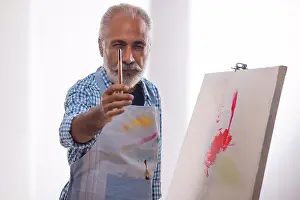 Prints of AN OLD MAN POSING IN FRONT OF CAMERA WITH PAINTBRUSH IN HAND August Prints: Print of an Old Man Holding a Paintbrush