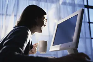 Young Woman Working From Home Prints: Side profile of a young woman using a computer