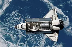 Space Shuttle Discovery Prints: Satellite view of a space shuttle with earth in the background