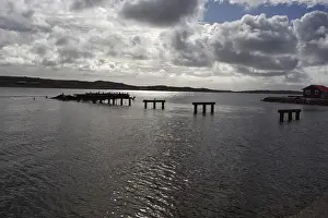British Overseas Territory Landscape Prints: Abandoned and half-destroyed pier structures under a cloudy sky