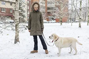 Thoroughbred Dog Images Prints: Affection Moment. Outdoor winter scene where woman shares tender moment with pet dog surrounded by snow and bare trees