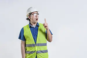 Young Engineer Prints: Amazed engineer pointing up isolated