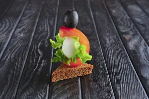 Prints of Appetizer for reception. Brown bread with quail egg, tomato, salad leaf and olive on skewer Brown Quail Prints: Brown Bread with Quail Egg Print
