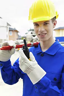 European Construction Work Prints: An apprentice / trainee. Construction worker on building site with helmet