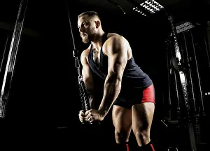 Muscular Build Workout Prints: The athlete performs an exercise on the triceps on a special device