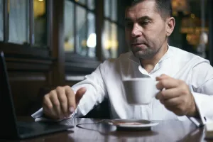 Man Working Online Prints: Authentic image of a businessman working in a cafe
