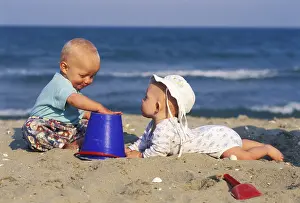 Young Children Playing Prints: Two babies playing at the beach