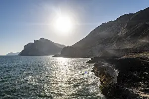 Deserted Rocky Coast Prints: Backlight of the rugged cliffs north of Mughsail beach